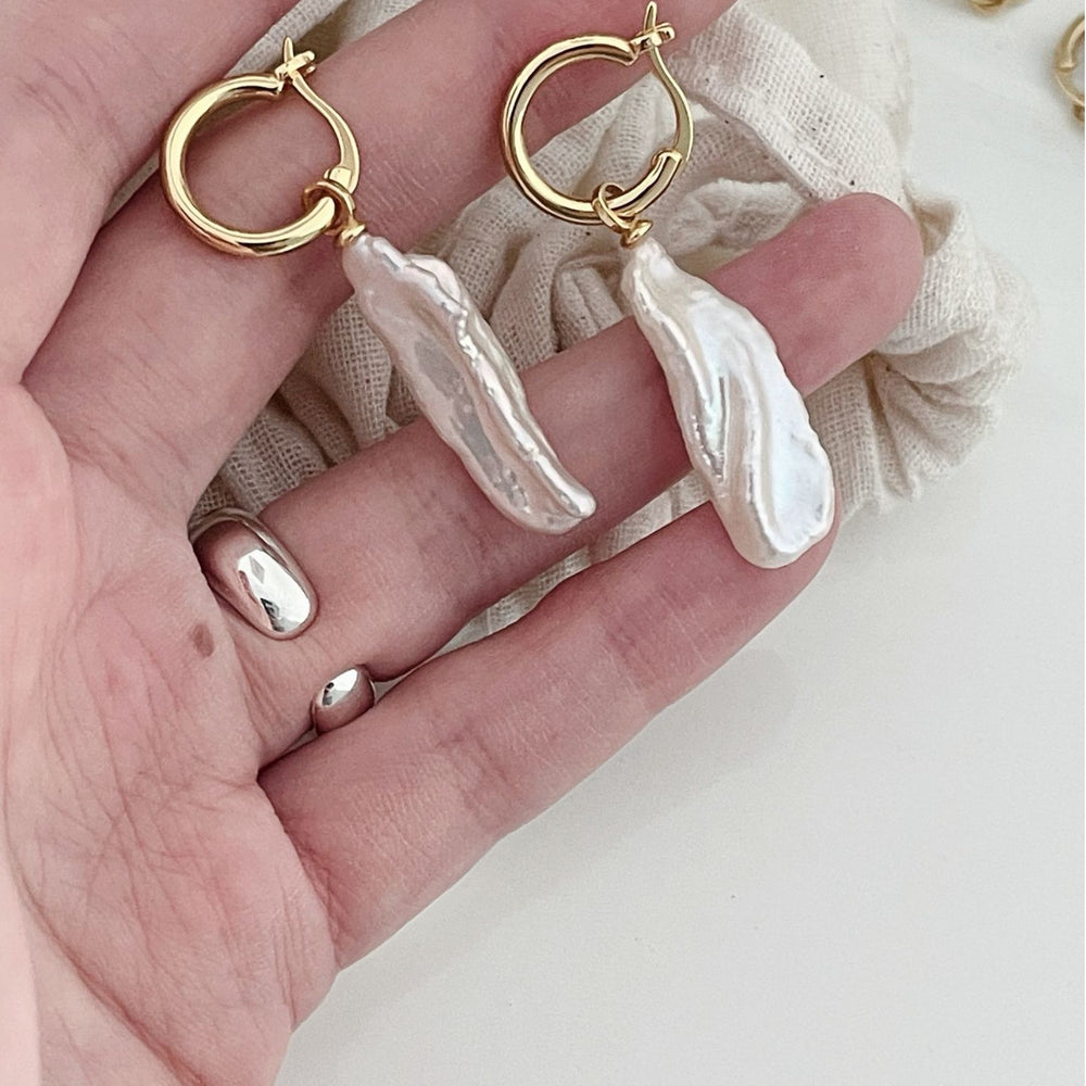 
                      
                        Elegant baroque pearl drop earrings with gold hoops, perfect for any occasion or outfit
                      
                    
