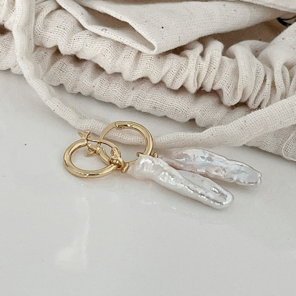 
                      
                        Baroque pearl drop earrings with elegant gold hoops for a sophisticated look
                      
                    