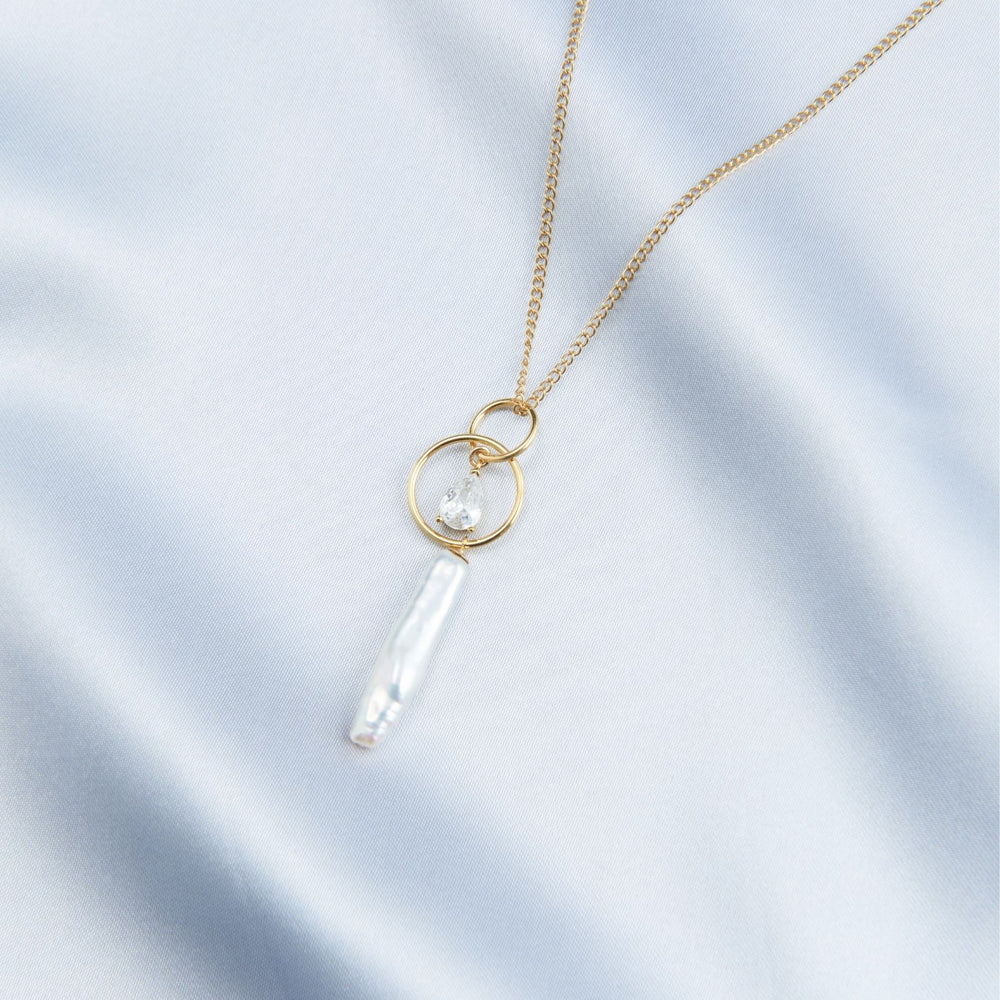 
                      
                        Elegant baroque pearl drop necklace on a delicate gold chain, showcasing unique pearl shapes
                      
                    