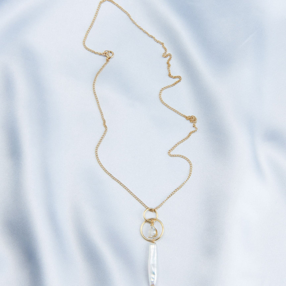 
                      
                        Delicate baroque pearl drop necklace on a gold chain, featuring a unique pendant design
                      
                    