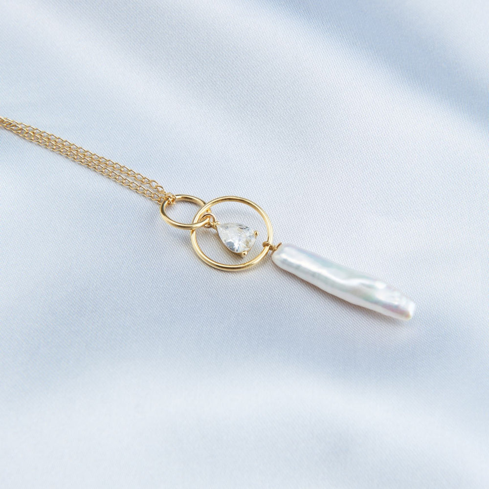 
                      
                        Elegant baroque pearl drop necklace with gold chain and circular pendant for a sophisticated look
                      
                    