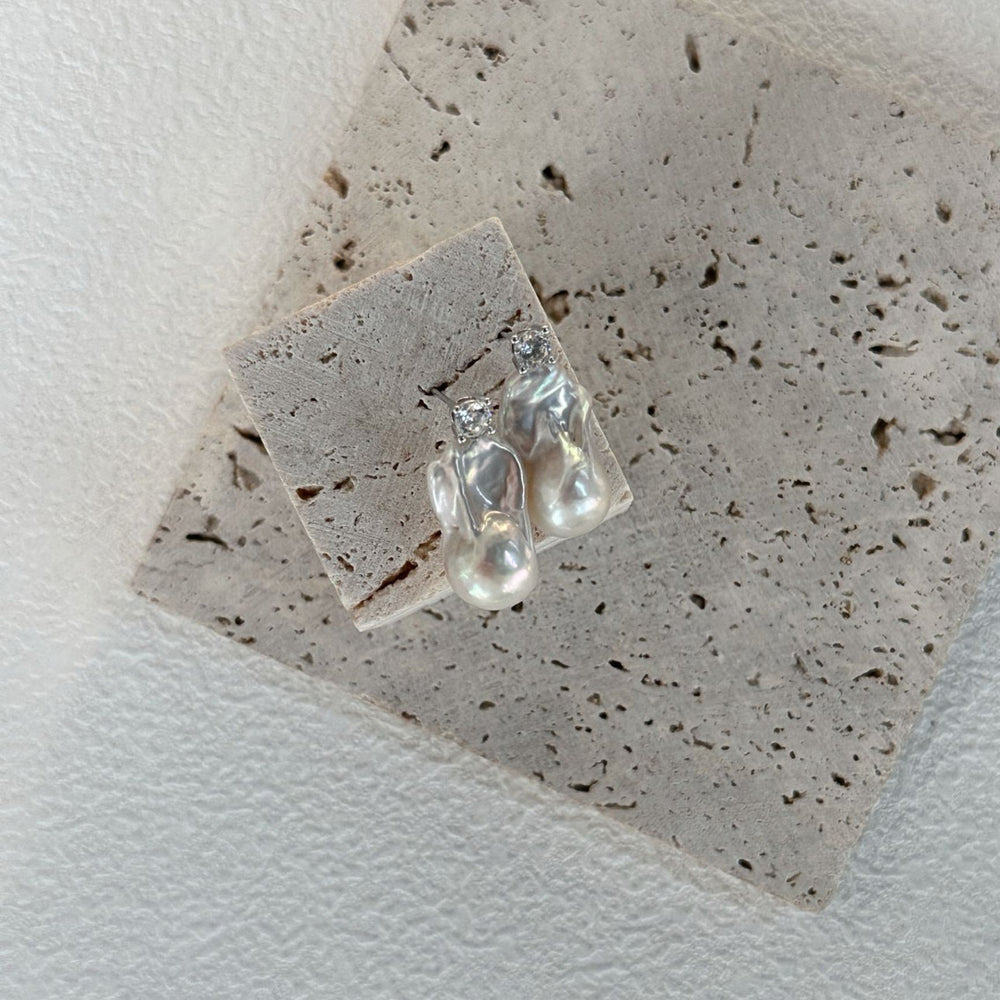 
                      
                        Baroque pearl earrings with silver accents showcasing unique shapes and lustrous finish
                      
                    