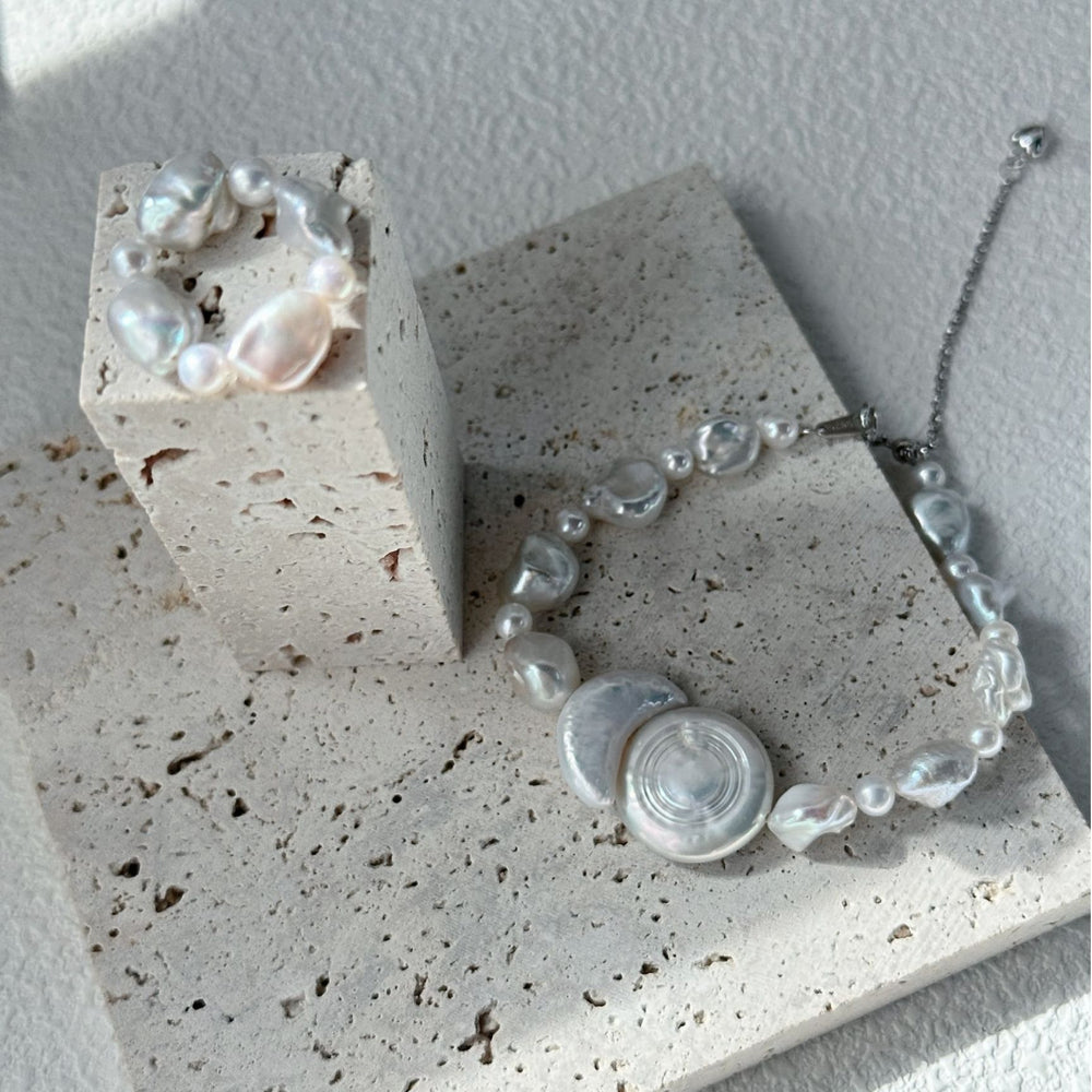 
                      
                        Elegant baroque pearl statement ring showcased on a textured surface with complementary jewelry
                      
                    