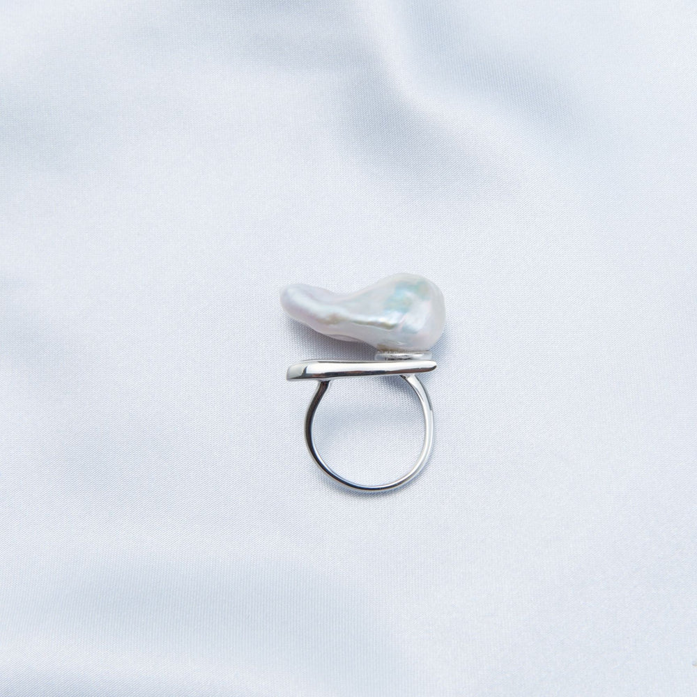 
                      
                        Bold baroque pearl ring with a unique shape on a smooth satin background
                      
                    