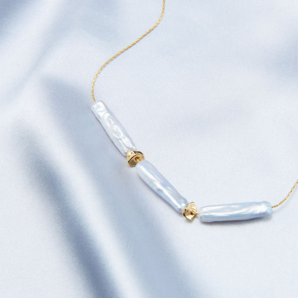
                      
                        Elegant baroque necklace featuring three unique pearl pieces on a delicate gold chain
                      
                    