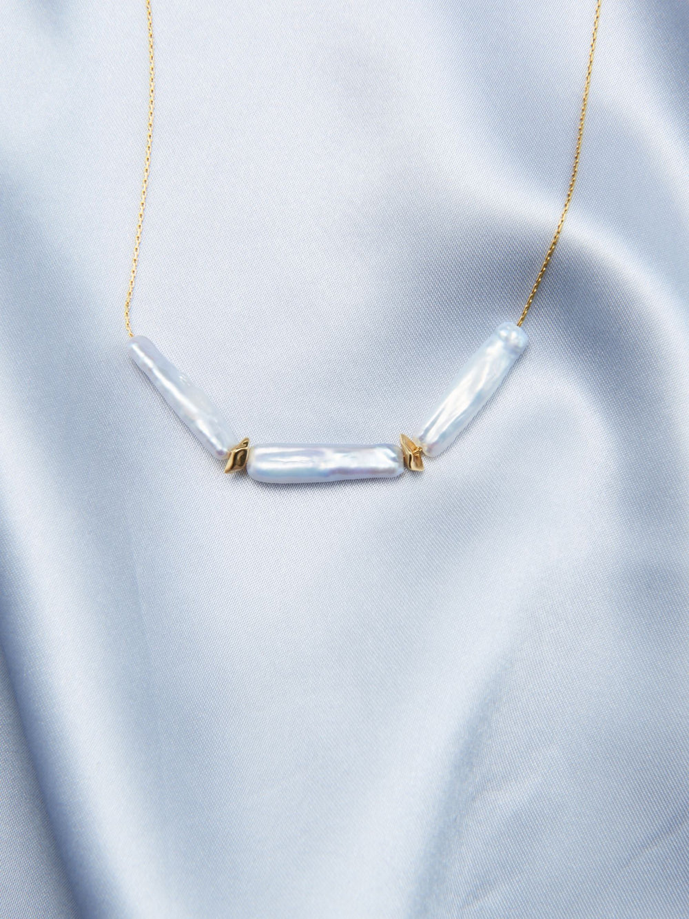Elegant baroque necklace featuring three lustrous pearls on a delicate gold chain