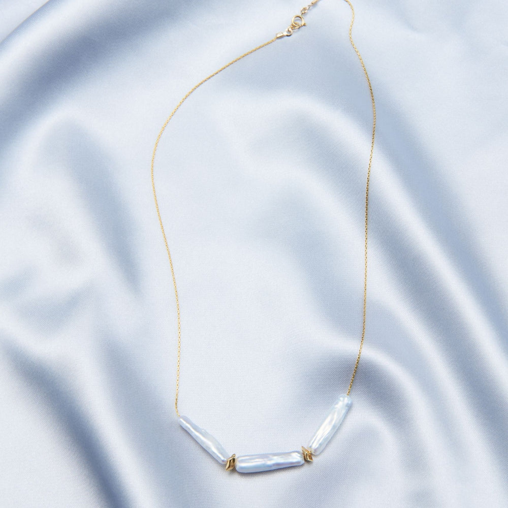 
                      
                        Elegant baroque necklace featuring three baroque pearls set on a delicate golden chain
                      
                    
