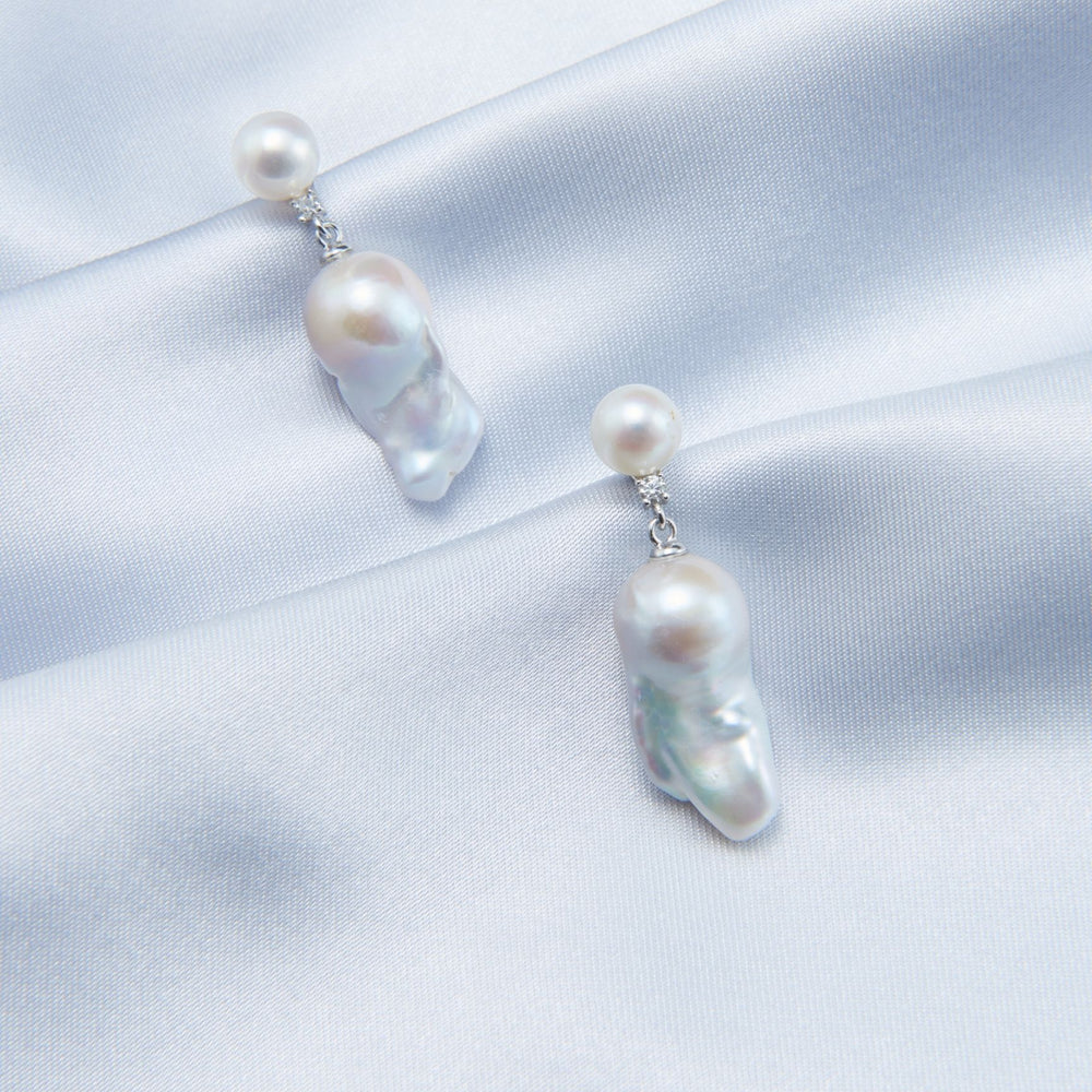 
                      
                        Elegant pearl accessories featuring unique drops with natural luster on a soft satin background
                      
                    