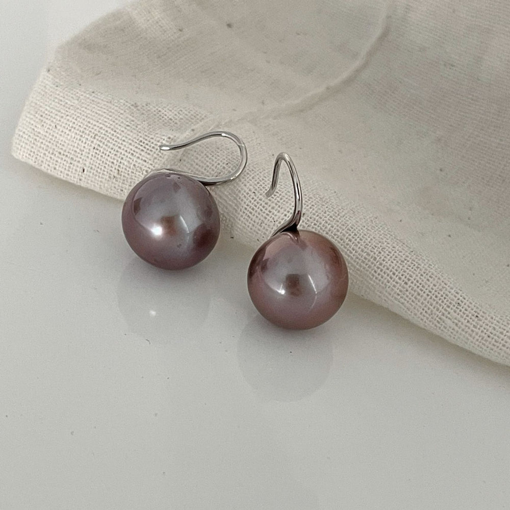 
                      
                        Elegant pearl earrings in soft pink with a glossy finish and silver hooks
                      
                    