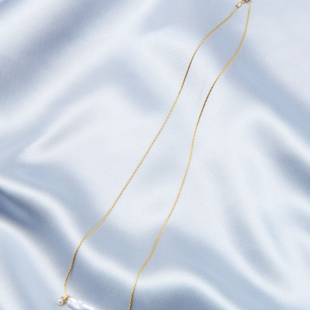 
                      
                        Elegant Pearl Necklace by Pearlra on a silky surface showcasing its delicate design
                      
                    