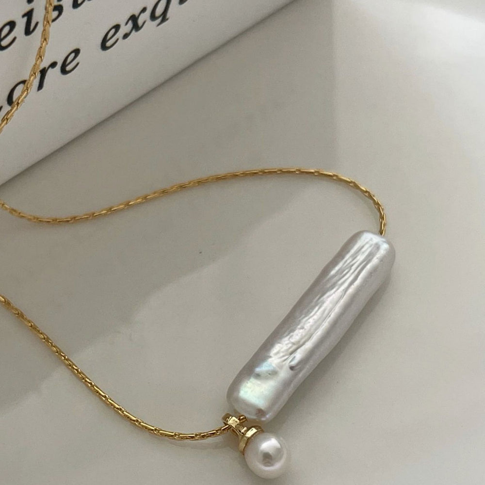 
                      
                        Elegant Pearl Necklace with a unique bar-shaped pearl and a delicate gold chain
                      
                    