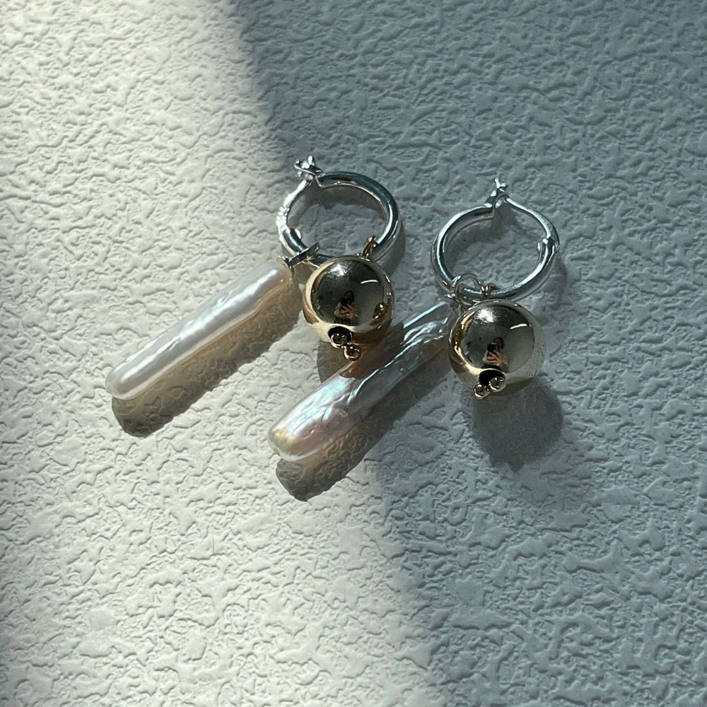 
                      
                        Luxury gold pearl earrings featuring elegant drop design with shiny silver accents
                      
                    