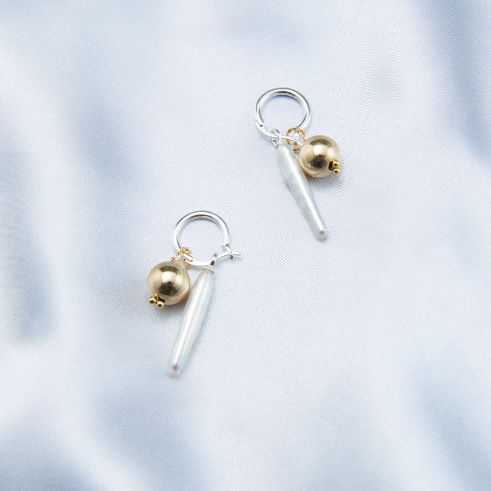 Luxury gold pearl earrings featuring a unique design with metallic accents