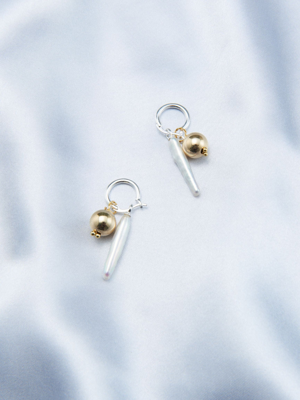 Luxury gold pearl earrings featuring a unique design with metallic accents