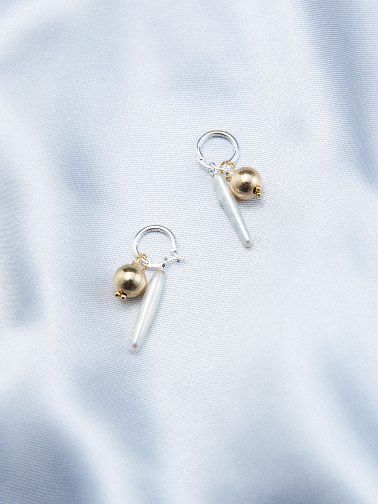 Luxury gold pearl earrings featuring a unique design with metallic accents