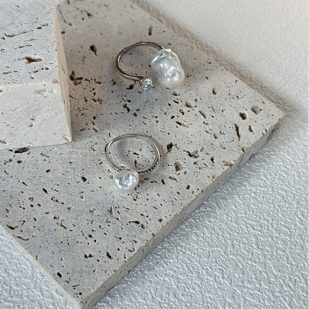 
                      
                        Elegant petite baroque pearl ring on a textured stone surface for a modern jewelry look
                      
                    