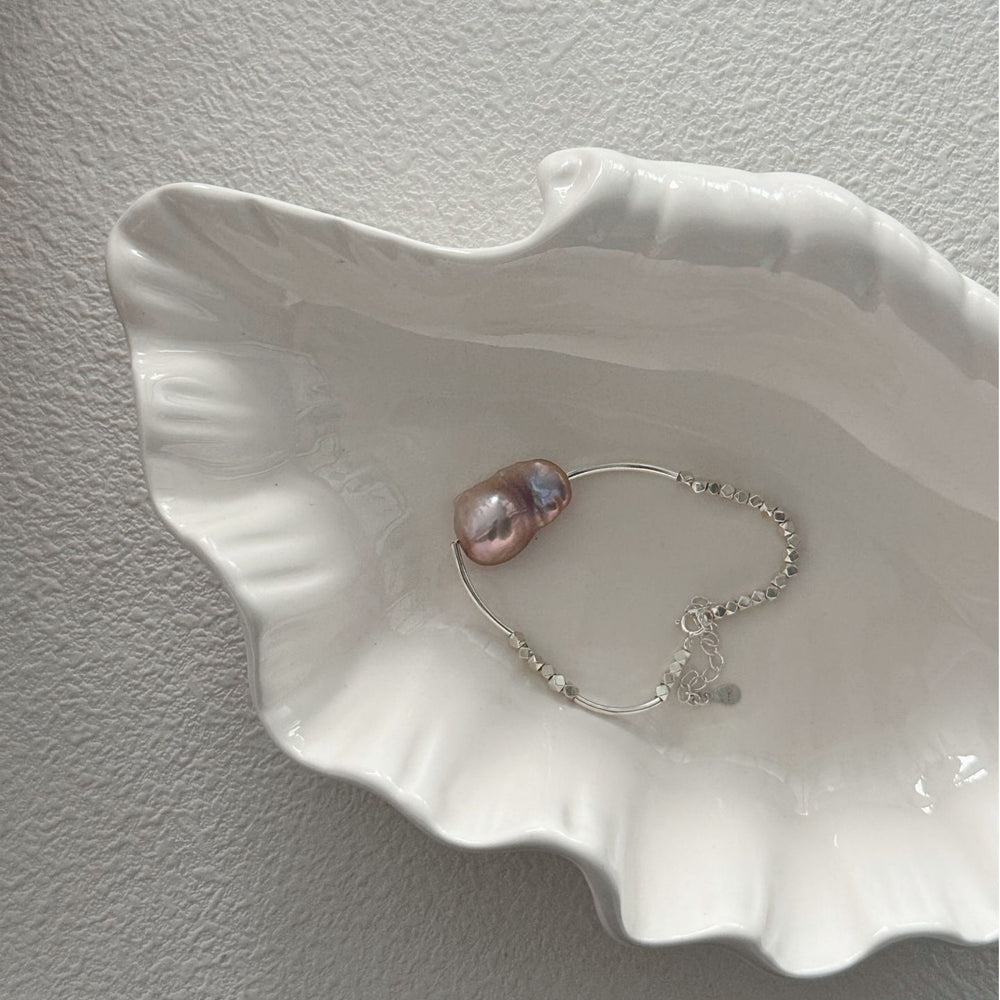 
                      
                        Pearlra sterling silver pearl bracelet displayed in a decorative shell-shaped dish
                      
                    