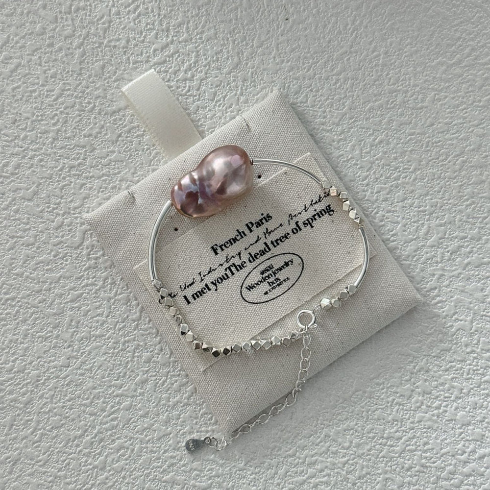 Sterling silver pearl bracelet featuring a uniquely shaped pink pearl and delicate chain detail