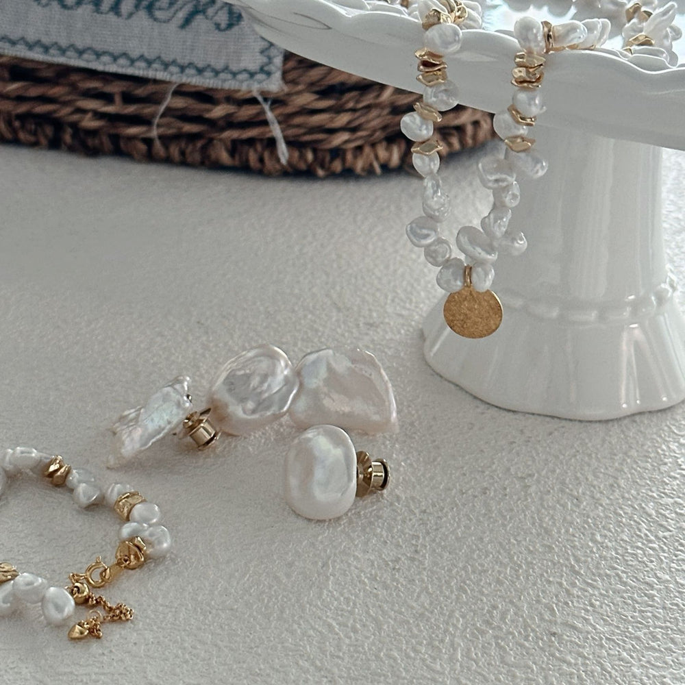 
                      
                        Unique baroque Pearl brooch displayed with matching pearl jewelry on an elegant pedestal dish
                      
                    