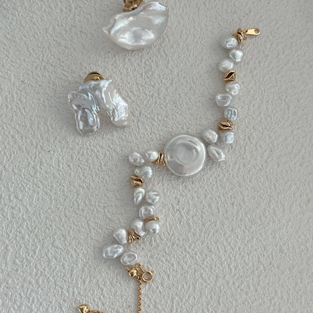 
                      
                        Unique baroque Pearl brooch set with matching earrings and a pearl bracelet in gold accents
                      
                    