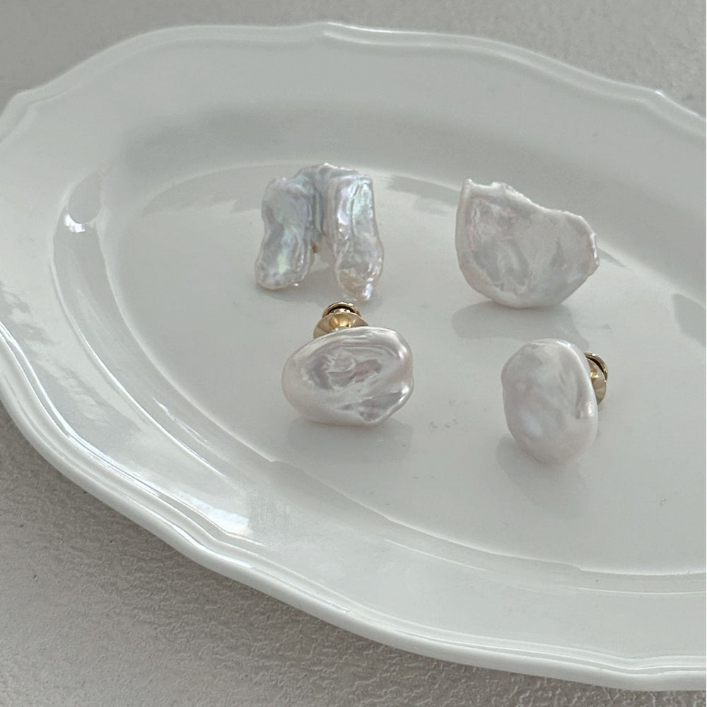 
                      
                        Unique baroque Pearl brooch in organic shapes displayed on a white serving plate
                      
                    