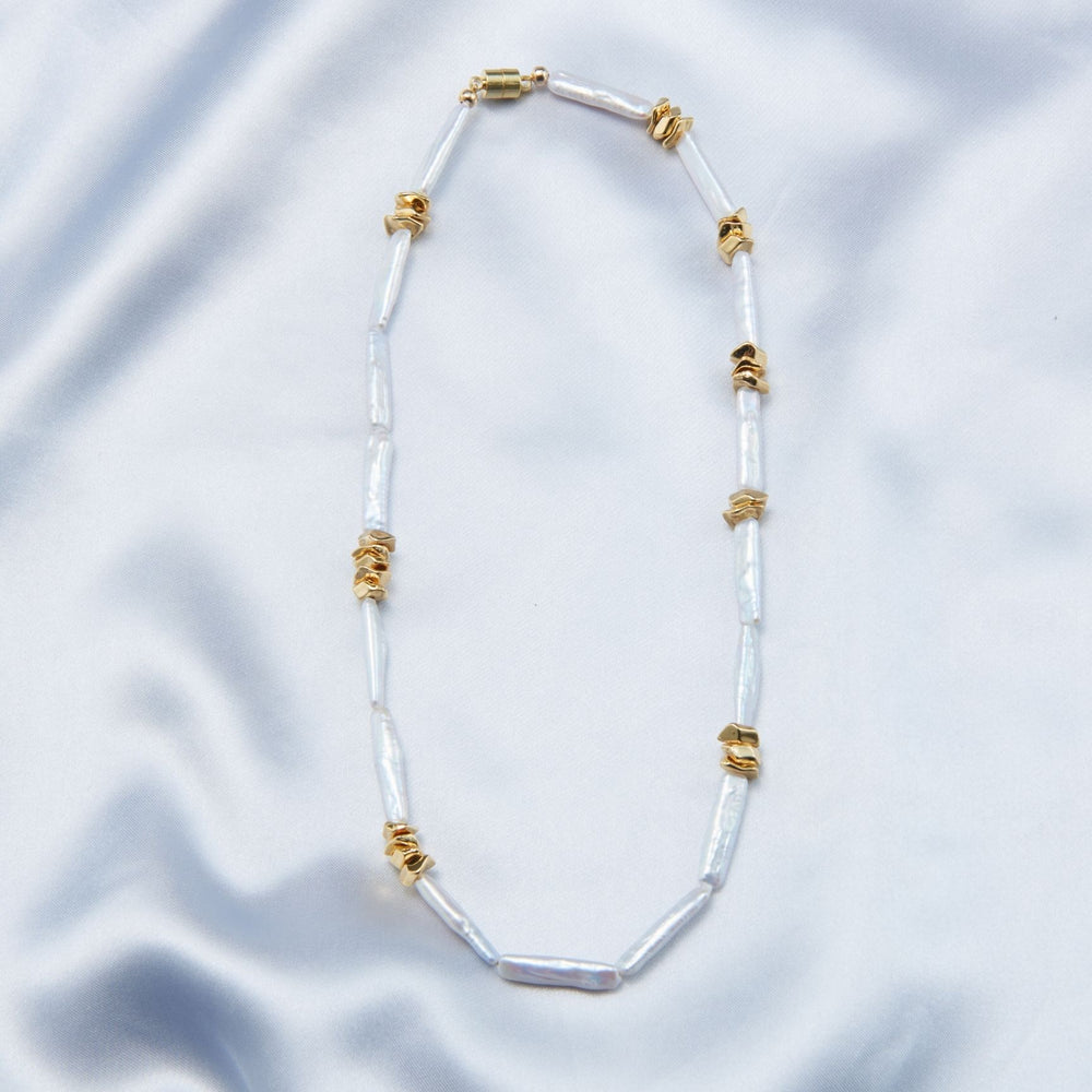 Unique pearl necklace design featuring elongated pearls and gold accents for a stylish look