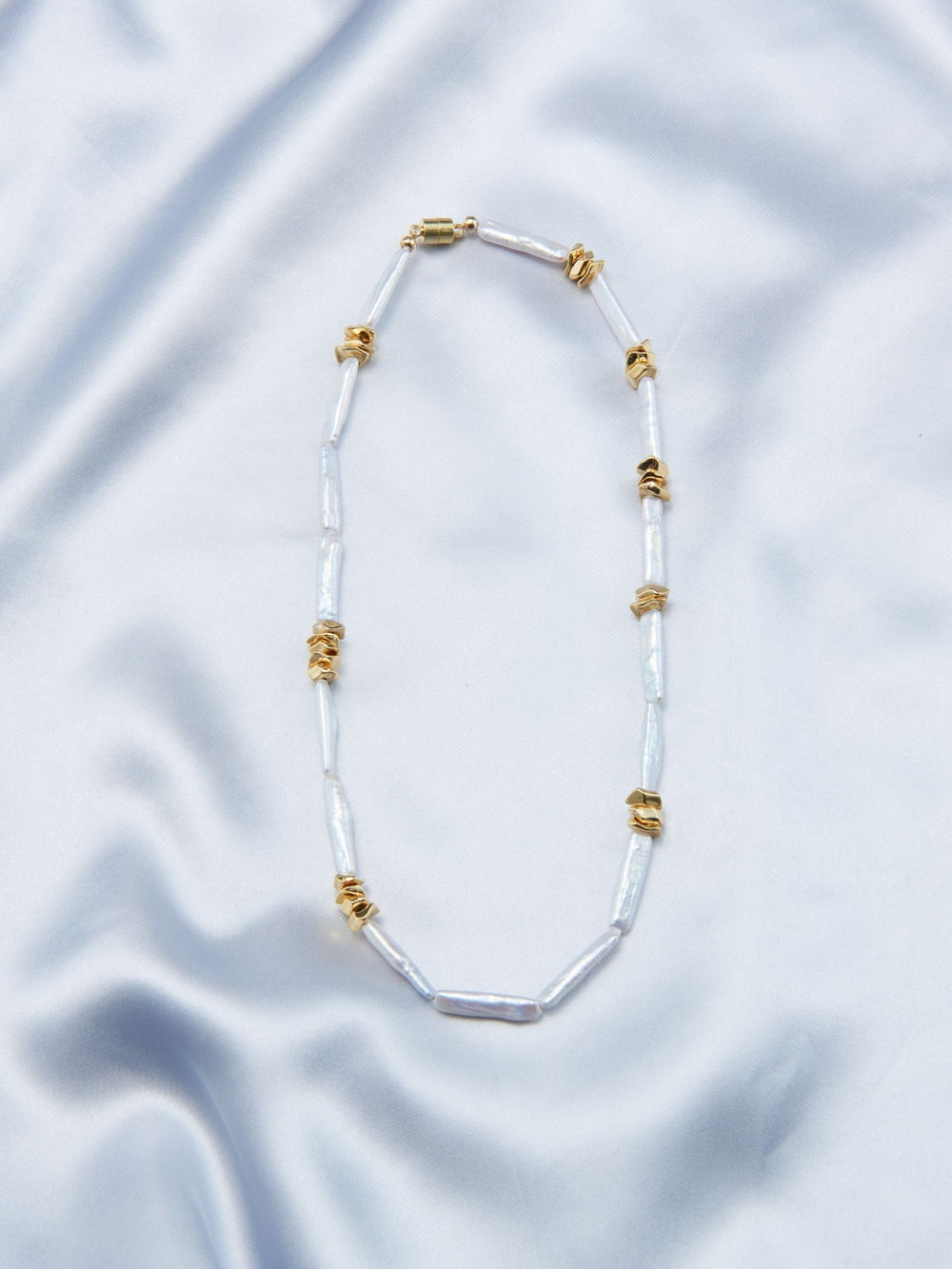 Unique pearl necklace design featuring elongated pearls and gold accents for a stylish look