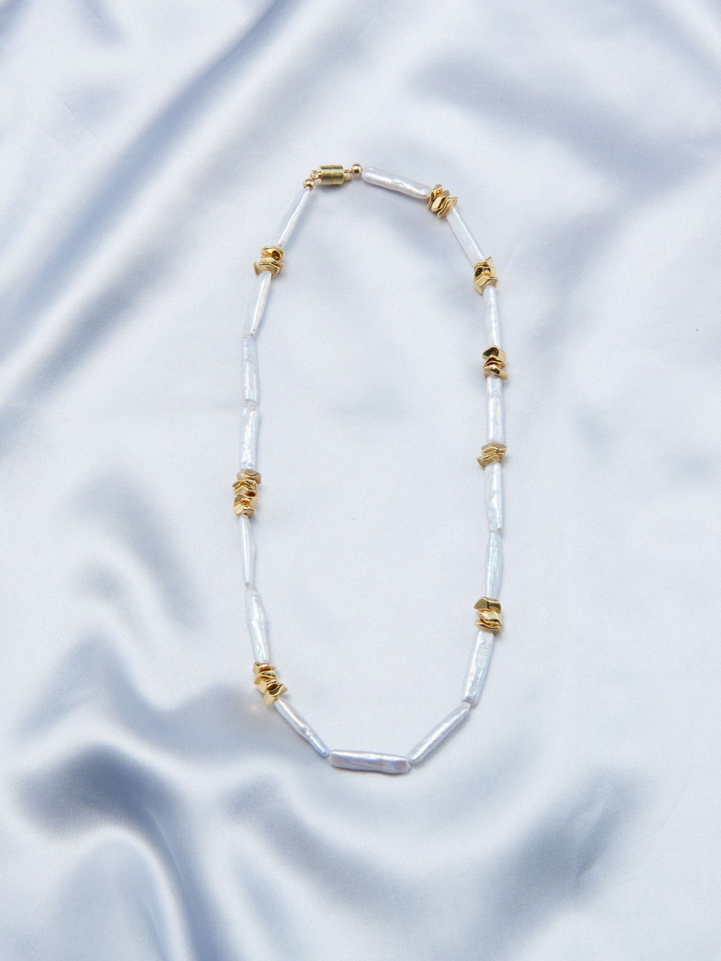 Unique pearl necklace design featuring elongated pearls and gold accents for a stylish look