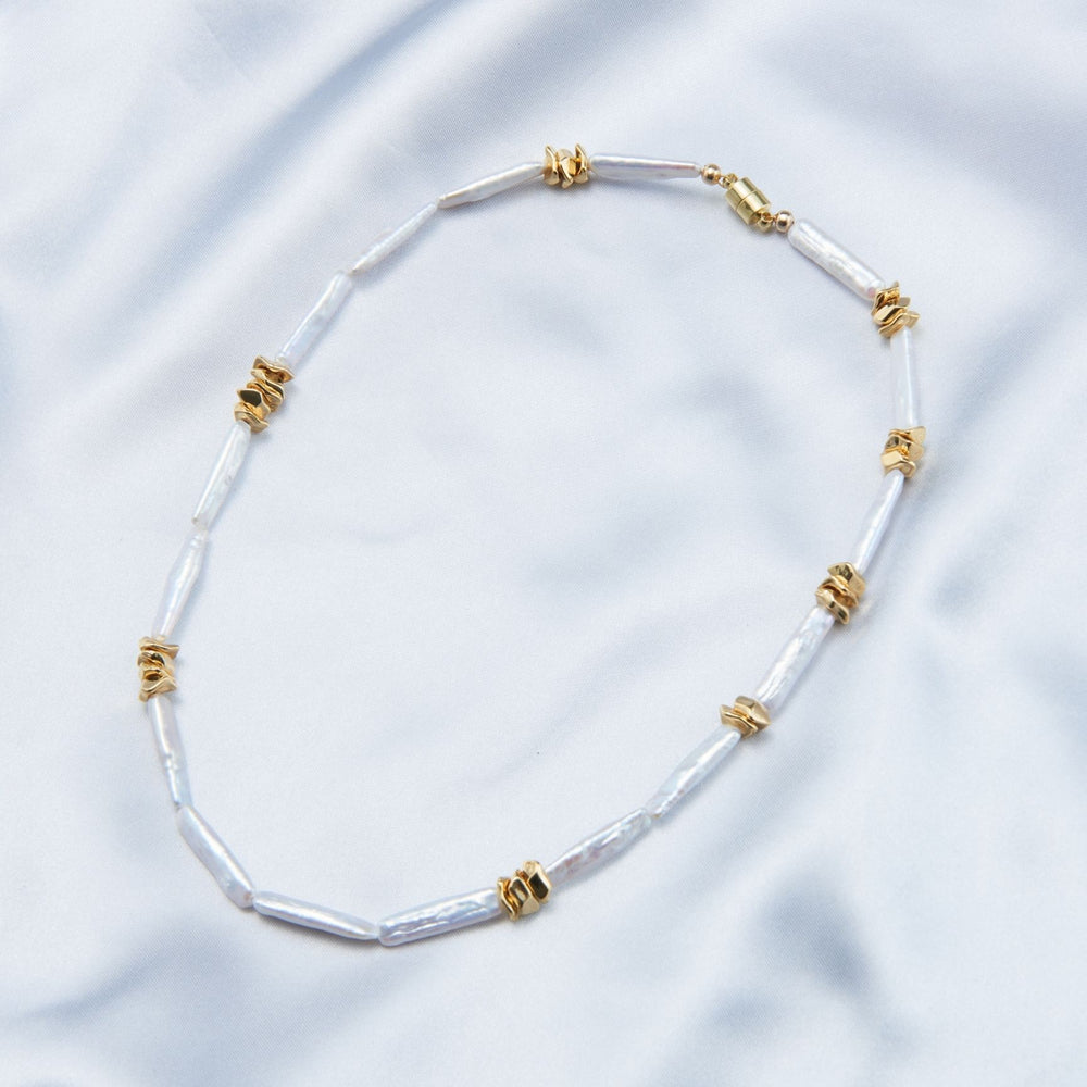 
                      
                        Unique pearl necklace design featuring elongated pearls with gold accents for elegant style
                      
                    