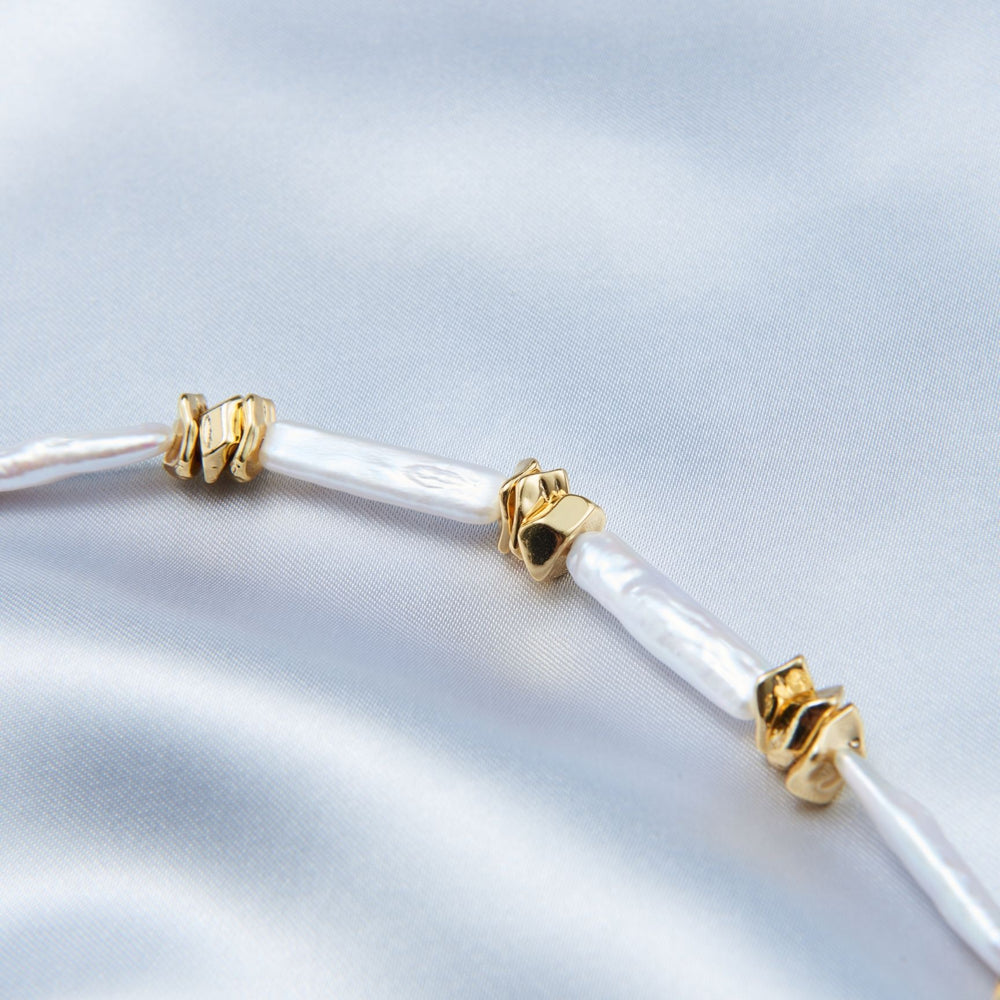 
                      
                        Delicate unique pearl necklace design featuring gold accents for elegant styling
                      
                    