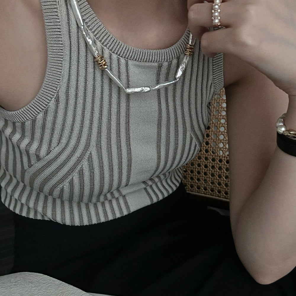 Elegant woman wearing a unique pearl necklace design with gold accents, perfect for stylish outfits
