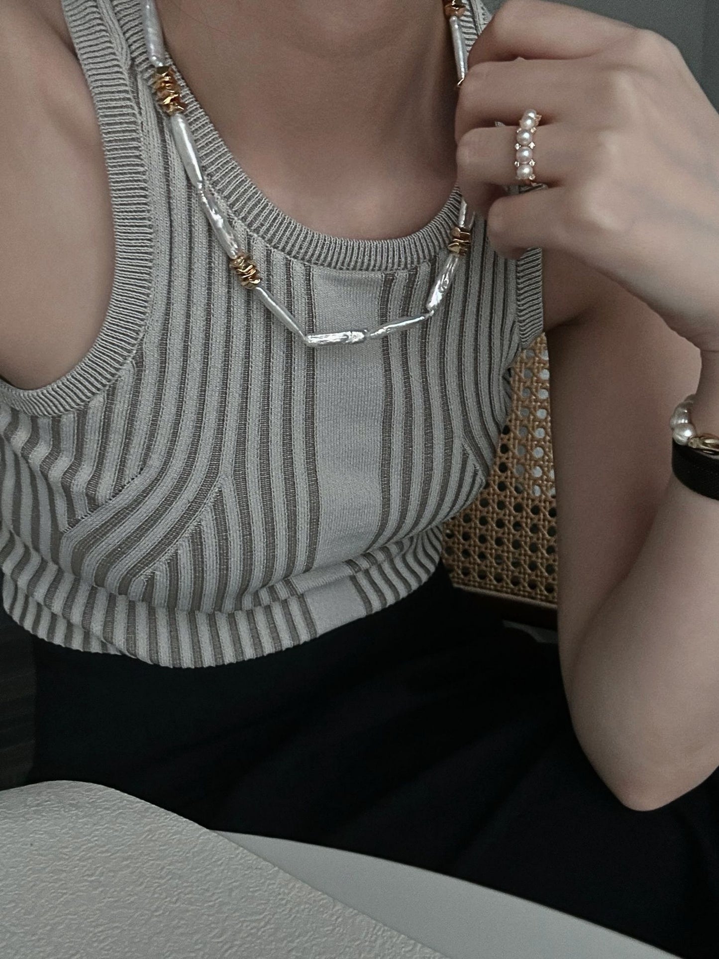 Elegant woman wearing a unique pearl necklace design with gold accents, perfect for stylish outfits